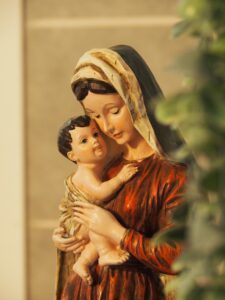 A serene statue depicting the Madonna and Child in warm tones.