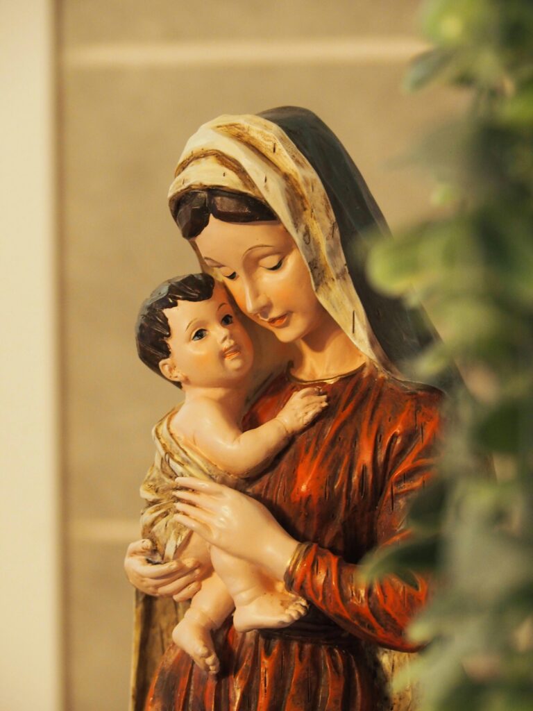 A serene statue depicting the Madonna and Child in warm tones.